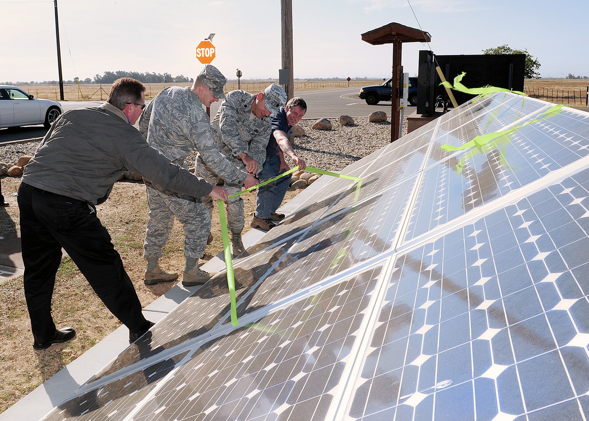 Danny Steinmetz, 9th Civil Engineer Squadron asset optimization chief, Col. Douglas Barron, 9th Mission Support Squadron commander, Lt. Col. Mark Shoviak, 9th CES commander, and Robert McBride, 9th CES, cut the ceremonial ribbon signifying the start of operation for the newly installed solar panel array at the main four-way stop sign intersection. The array will power the main information marquee for Beale AFB.  (U.S. Air Force photo/Mr. John Schwab)