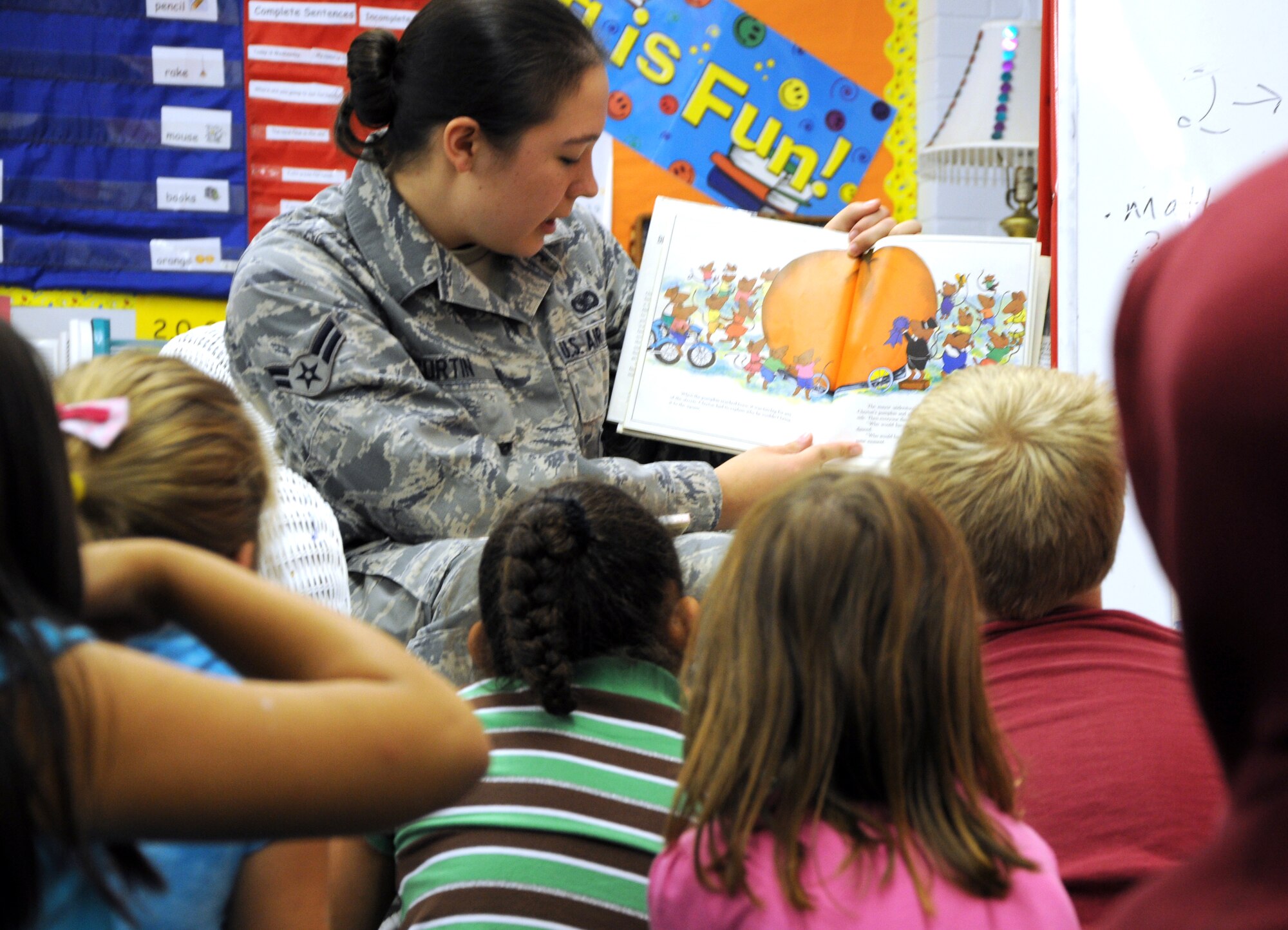 SAN ANGELO, Texas -- Airman 1st Class Kadey Curtin, 17th Security Forces Squadron, reads a Halloween story to kindergarteners at Belaire Elementary School Oct. 31 as part of Read and Treat.  The event, sponsored by the 17th SFS, had volunteers reading stories and handing out candy to 11 classes ranging from kindergarten to second grade to celebrate Halloween. (U.S. Air Force photo/Airman 1st Class Jessica Keith)

