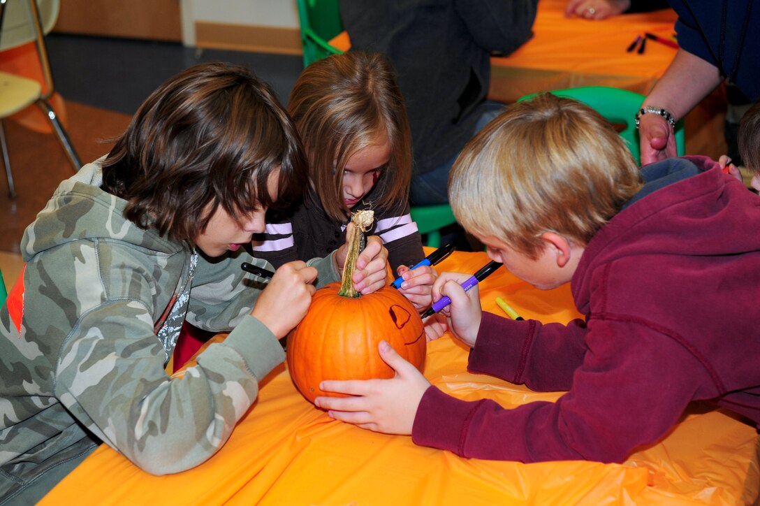 Children decorate pumpkins during the annual Family Fall Fest at Langley Air Force Base, Va., Oct. 28, 2011. The festival included five different Halloween activities for more than 150 children to celebrate the holiday. (U.S. Air Force photo by Airman 1st Class Kayla Newman/Released) 