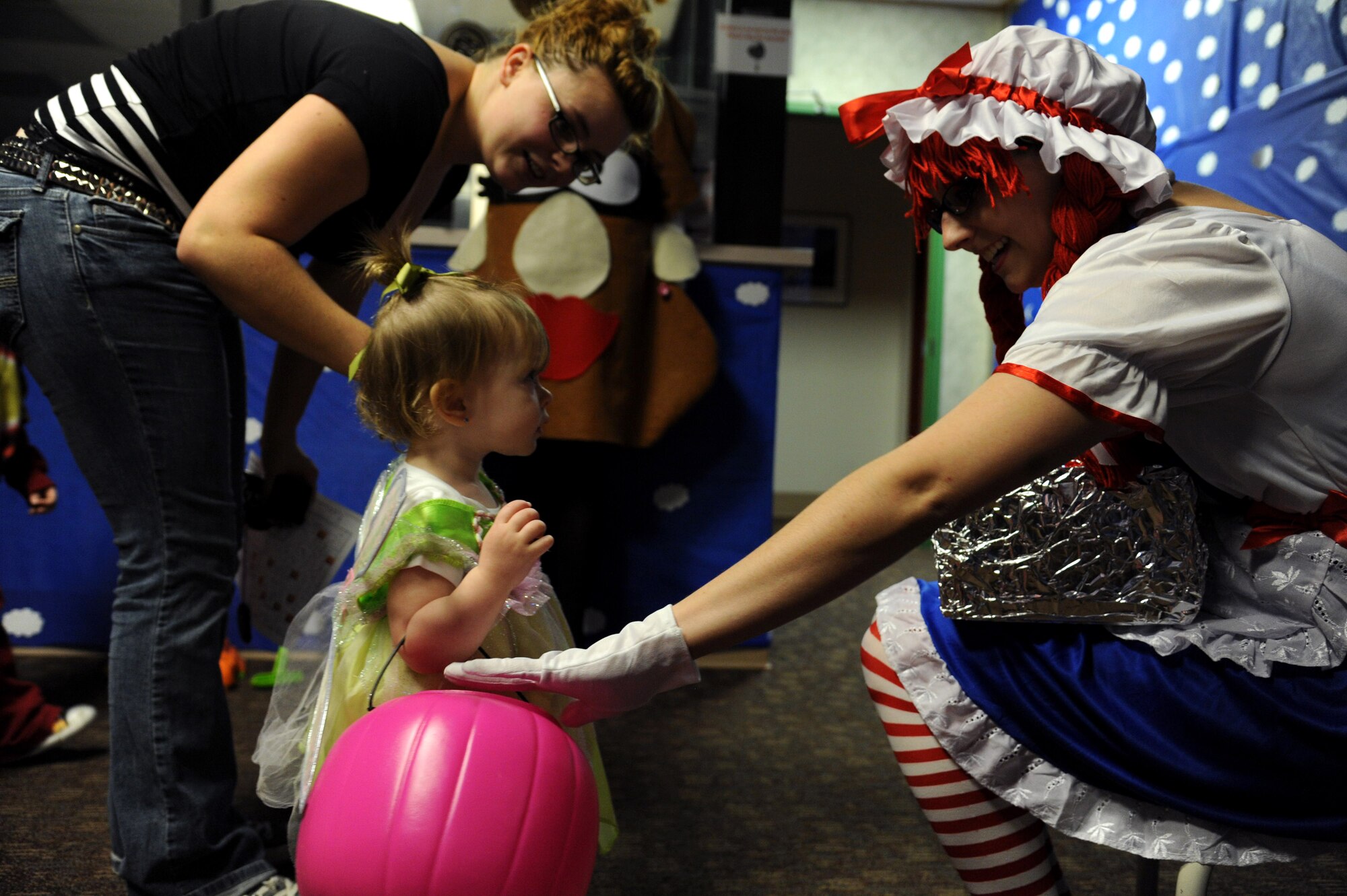 U.S.  Air Force Staff Sgt. Jennifer Lively, 319th Medical Operations Squadron mental health technician, hands out candy to a child at the clinic on Grand Forks Air Force Base, N.D., on Oct. 31, 2011.  The 319th Medical Group hosts trick or treating every year as a way for children and families to enjoy the holiday.  (U.S. Air Force photo by Airman 1st Class Xavier Navarro)