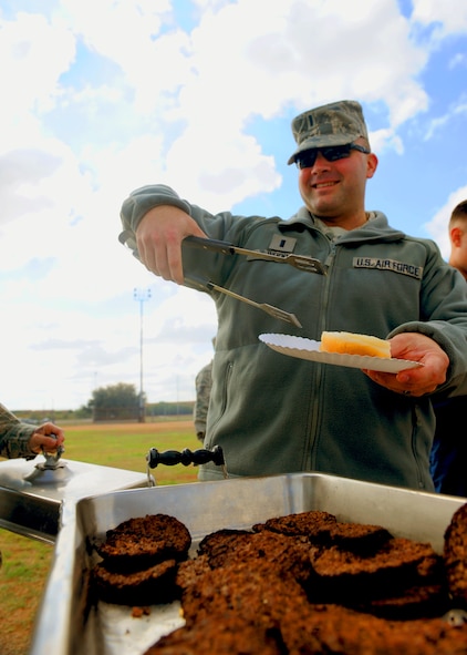1st Lt. Jonathon Wood, 7th Logistics Readiness Squadron,  helps himself to a burger during the burger burn Oct. 28, 2011, at Dyess Air Force Base, Texas. The burger burn was hosted by the Combined Federal Campaign commitee. (U.S. Air Force photo by Airman 1st Class Cierra Bullock/Released)