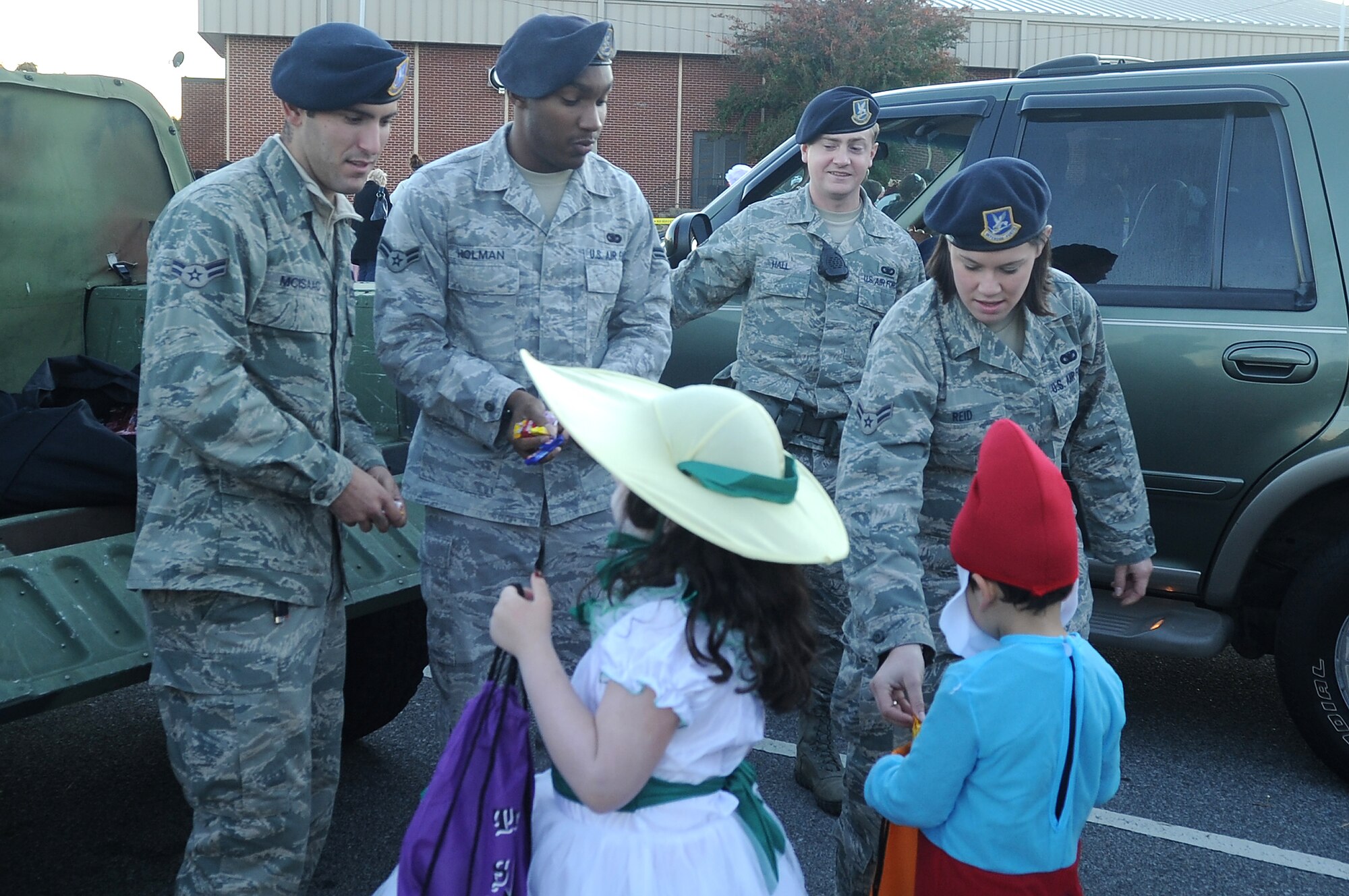 U.S. Air Force (from left) Airman First Class Brett McIssac, Airman First Class Justin Holman, Senior Airman Adam Hall, and Airman First Class Kirstin Reid, all from the 20th Force Support Squadron Security Forces, give candy out to local children at Shaw?s Halloween celebration, Boo Bash, at Shaw Air Force Base, S.C., Oct. 29, 2011. The Boo Bash is held annually for military families to enjoy the festivities. (U.S. Air Force photo by Airman First Class Hunter Brady/Released)



