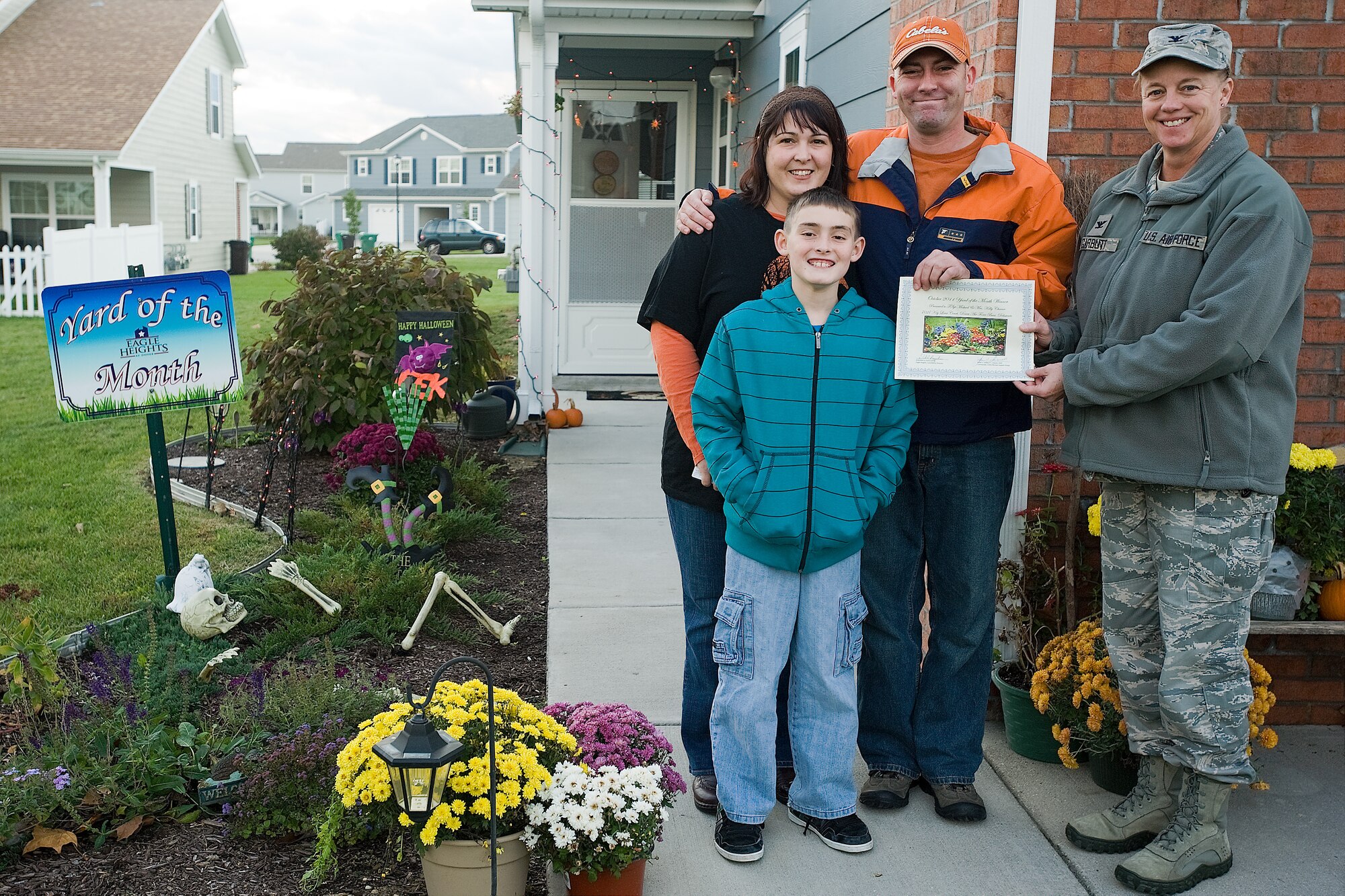 Col. Joan Garbutt, right, commander of the 436th Mission Support Group, stands with Michael Chance, his wife Kelly and son Corey, recognizing the Chance family as the Falcon View Yard of the Month winners for October at Dover Air Force Base, Del. (U.S. Air Force photo by Airman 1st Class Samuel Taylor)

