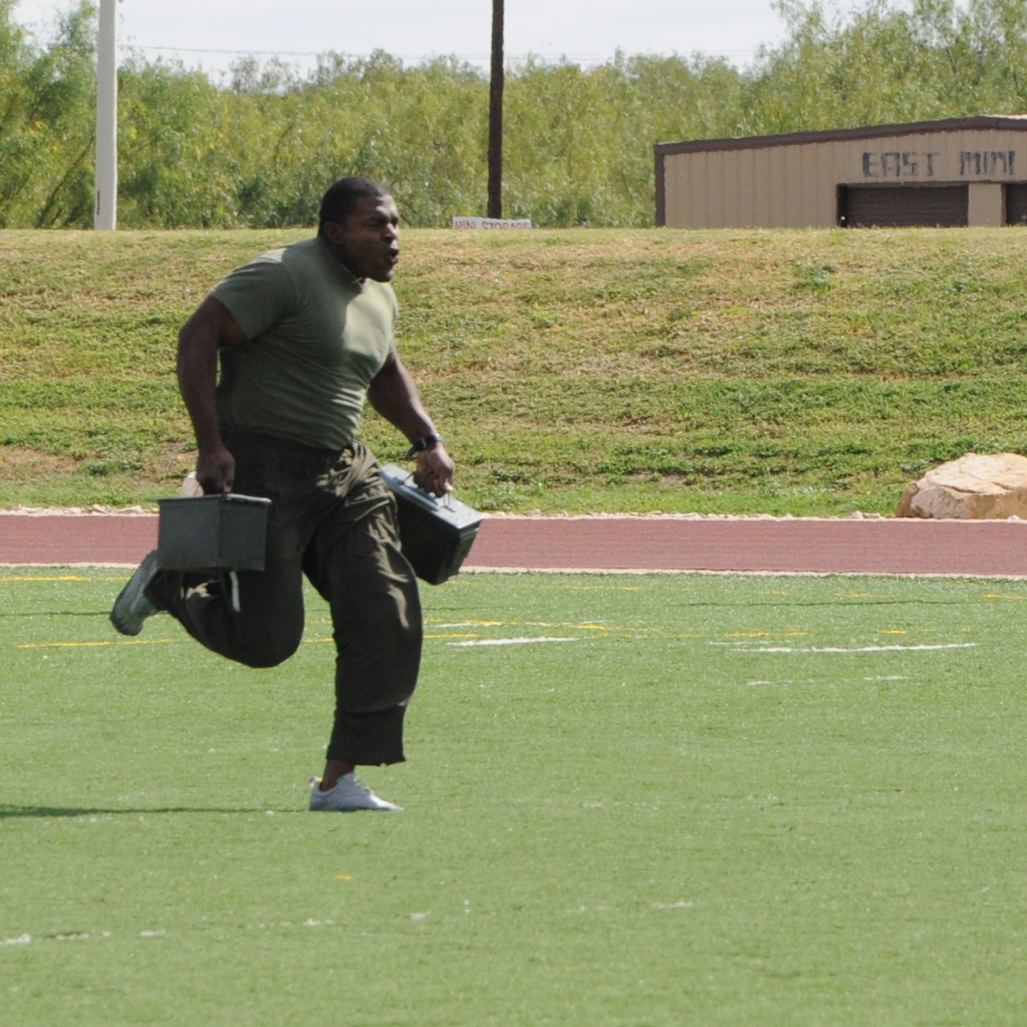 GOODFELLOW AIR FORCE BASE, Texas--  Marine Staff Sgt. Adam Slaughter, Marine Corps Detachment, sprints across the Mathis Fitness Center football field, while carrying to ammunition cases filled with dirt, during the Sports Day obstacle course. Only the top scoring squadrons got to compete in this event. Points were tallied based on participation as well as number of wins. (U.S. Air Force photo/Airman 1st Class Jessica Keith)