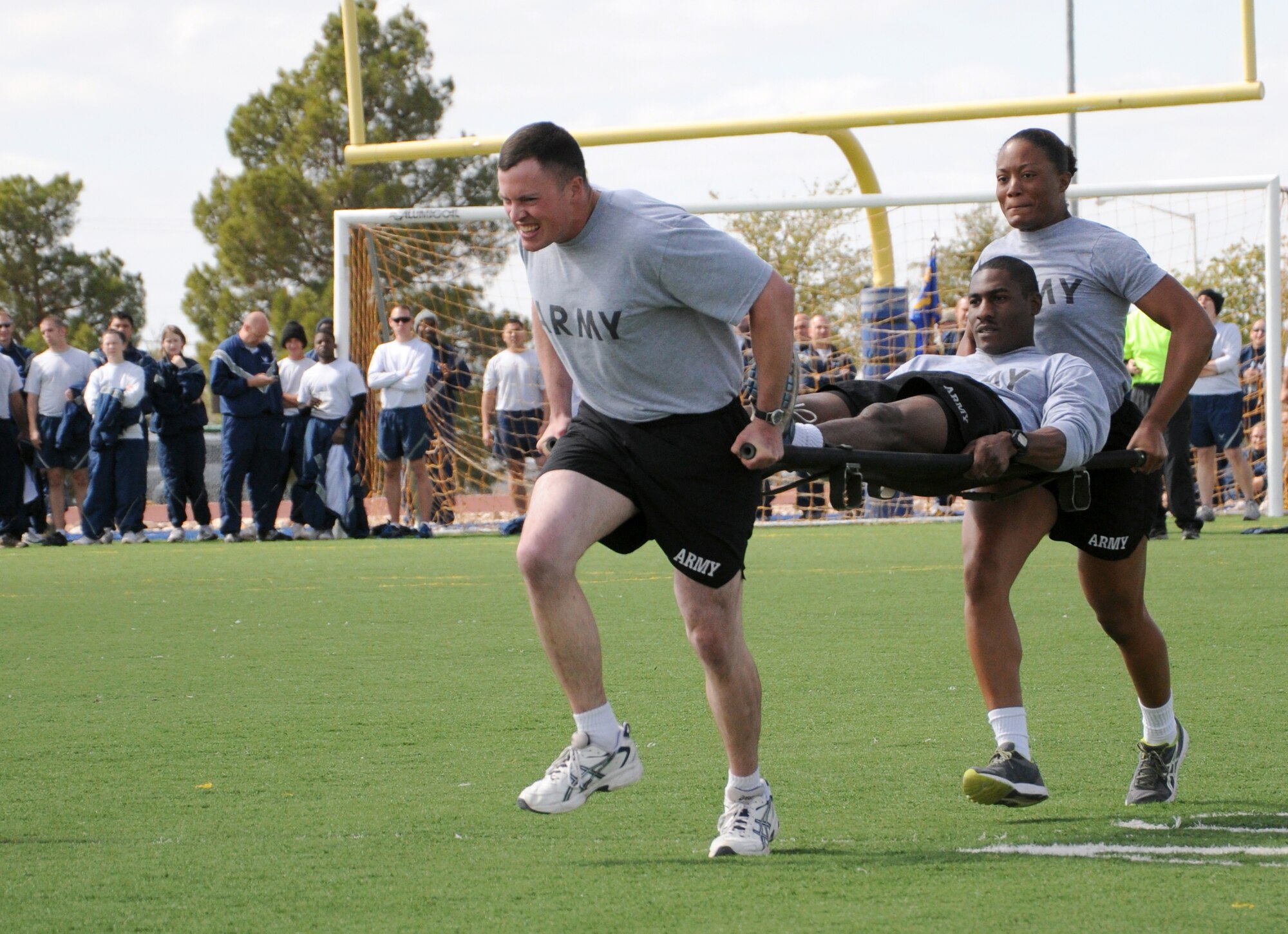 GOODFELLOW AIR FORCE BASE, Texas—344th Military Intelligence soldiers carry their teammate 40 yards during the first leg of the final event of the quarterly Sports Day, Oct. 28. Only the top scoring squadrons got to compete in this event. Points were tallied based on participation as well as number of wins. (U.S. Air Force photo/Airman 1st Class Jessica Keith)