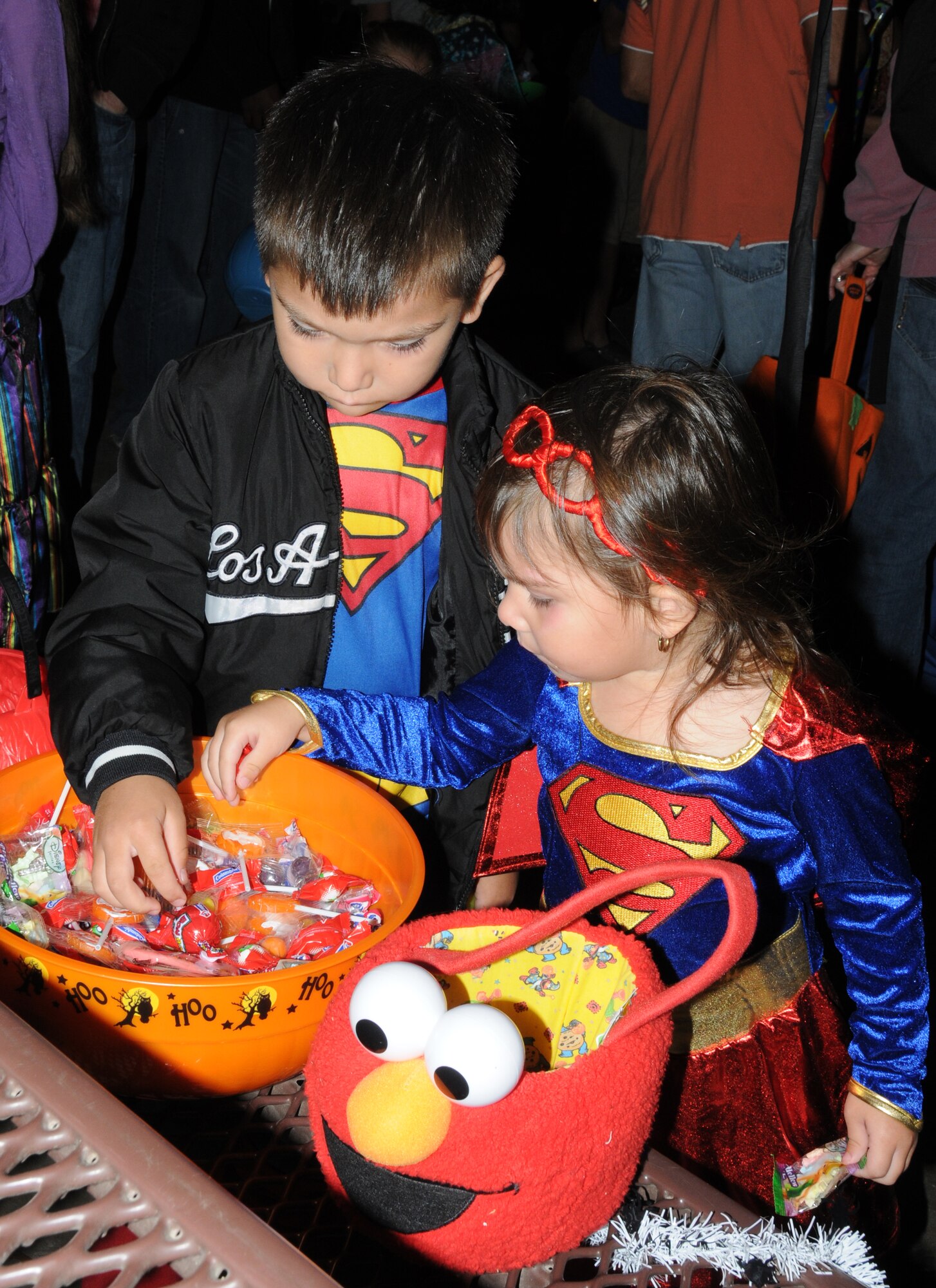 Andrew Stevenson, 5, and his sister, Bella, 3, dressed as Superman and Superwoman, help themselves to some free candy during Ghouls in the Park Oct. 28, 2011, at Keesler Air Force Base, Miss. The events’ activities include a costume contest, pumpkin painting, hay rides and a haunted house.  Andrew and Bella’s mom is Staff Sgt. Sally Stevenson, 81st Medical Support Squadron.  (U.S. Air Force photo by Kemberly Groue)