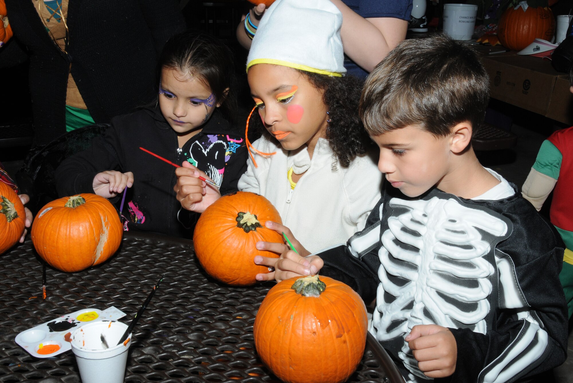 Leticia Thompson, 7, Kaleah Suddeth, 10, and Troy Suddeth, 7, paint pumpkins during Ghouls in the Park Oct. 28, 2011, at Keesler Air Force Base, Miss.  Kaleah and Troy’s parents are Kevin and Jamie Suddeth, 81 Force Support Squadron and Leticia is their cousin.  The events’ activities include a costume contest, hay rides and a haunted house.  (U.S. Air Force photo by Kemberly Groue)