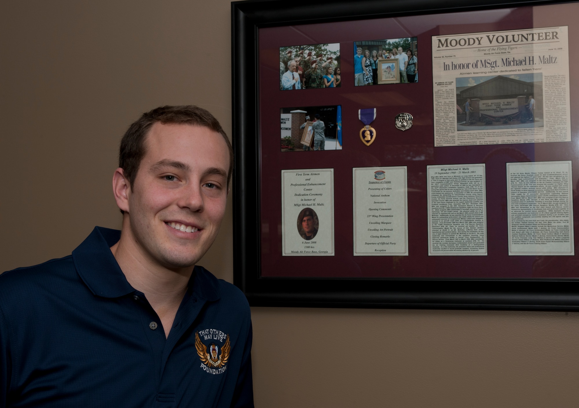 Kyle Maltz stands next to a framed collection of memorabilia dedicated to his father, U.S. Air Force Master Sgt. Michael Maltz, at the First Term Airmen and Professional Enhancement Center at Moody Air Force Base, Ga., Oct. 21, 2011. Kyle Maltz is now working on his Master of Business Administration at Western Washington University, Wash. (U.S. Air Force photo by Airman 1st Class Jarrod Grammel/Released)
