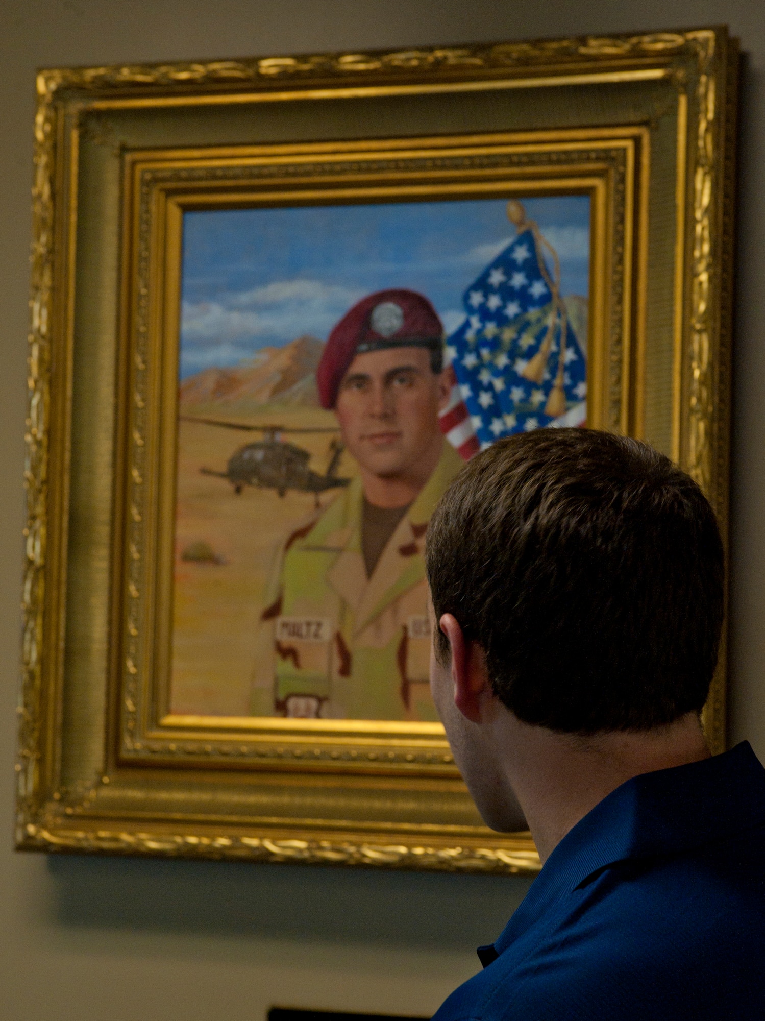 Kyle Maltz looks at a painted portrait of his father, U.S. Air Force Master Sgt. Michael Maltz, in the First Term Airmen and Professional Enhancement Center at Moody Air Force Base, Ga., Oct. 21, 2011. Sergeant Maltz was deployed from Moody to Afghanistan when he and six crew members were killed in a helicopter crash while on a mission to transport children to a hospital. (U.S. Air Force photo by Airman 1st Class Jarrod Grammel/Released)
