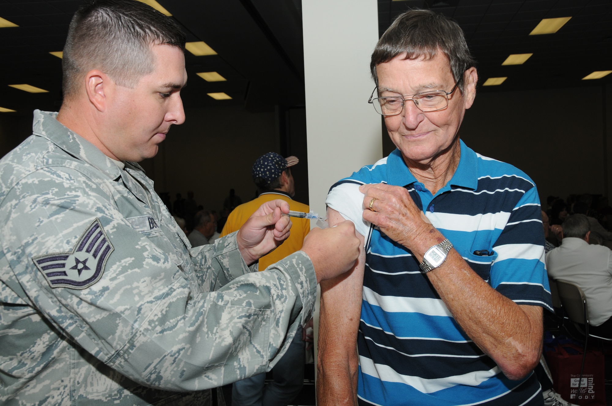 Staff Sgt. James Bowden, 81st Medical Operations Squadron, gives a flu shot to Harry Smith, a retired Air Force member from Biloxi, during Retiree Appreciation Day Oct. 28, 2011, at the Roberts’ Consolidated Aircraft Maintenance Facility at Keesler Air Force Base, Miss.  The annual event included door prizes, more than 30 displays with information pertinent to retirees and a free lunch.  (U.S. Air Force photo by Kemberly Groue)
