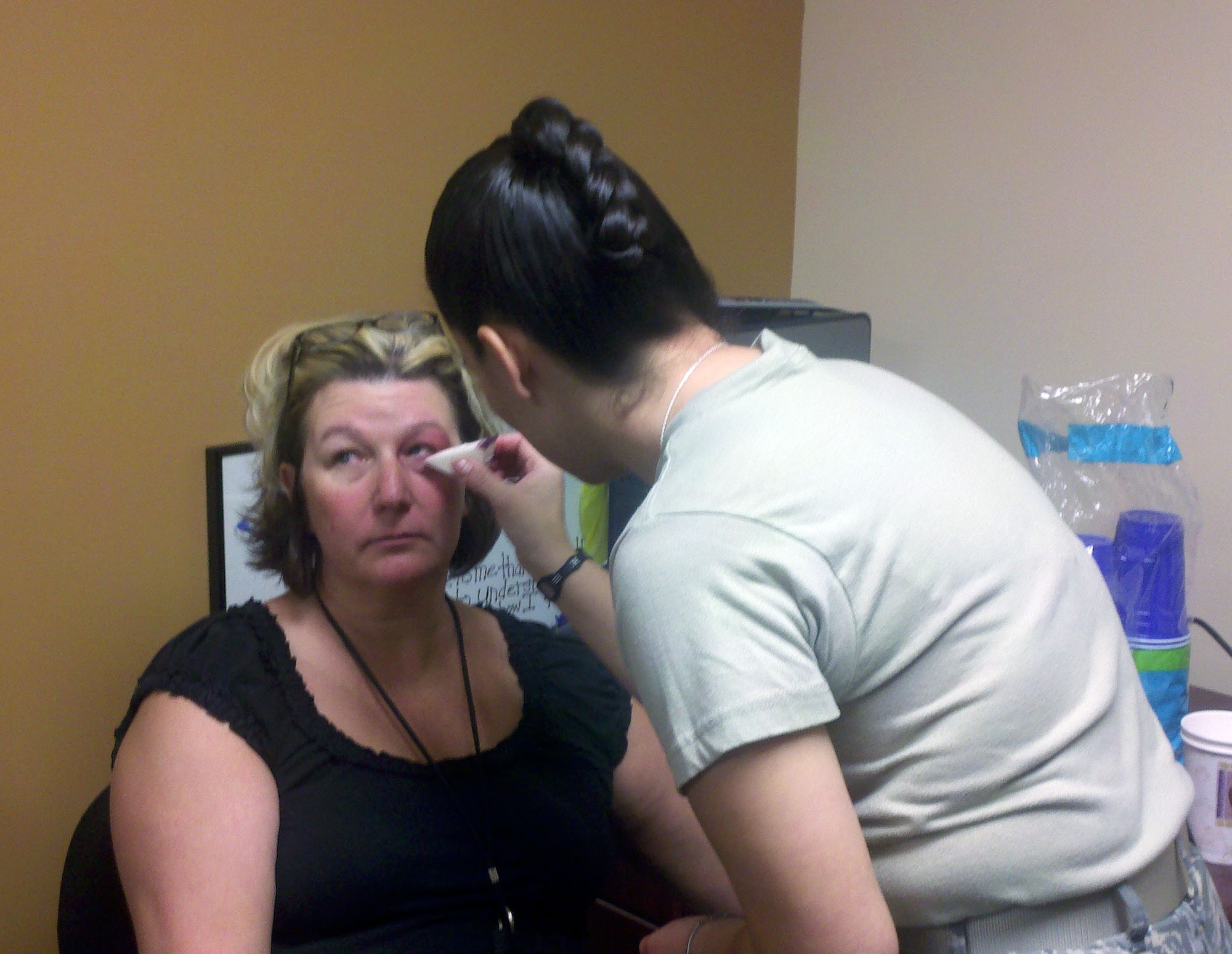 Lynn Stanley, health systems specialist, 95th Medical Support Squadron, gets a black eye applied by Staff Valerie Vasquez, superintendent, 95th Medical Support Squadron. (Courtesy Photo) 