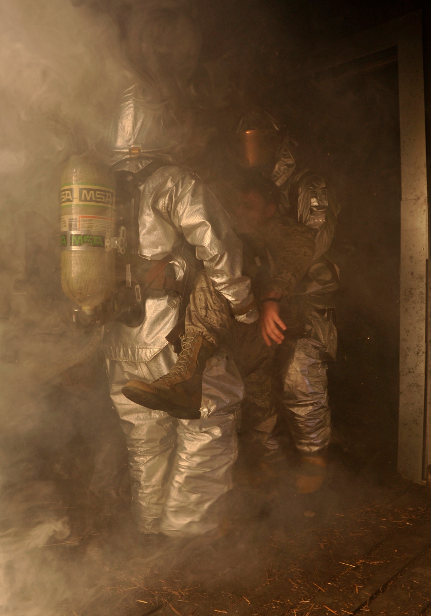 Senior Airman Curtis Sinkfield and Airman Darby Parker,  both 19th Civil Engineer Squadron firefighters, carry Senior Airman Shaughn Bader, 19th CES rescue technician, (simulated casualty),  out of a building Oct. 28, during a building clearing and structural fire training scenario at Little Rock Air Force Base, Ark. The firefighting team consists of 55 personnel, and has received 65 types of individual and team recognitions in the past year, including a “superior team” award for their performance during the operational readiness inspection. (U.S. Air Force photo by Senior Airman Caleb Pierce)