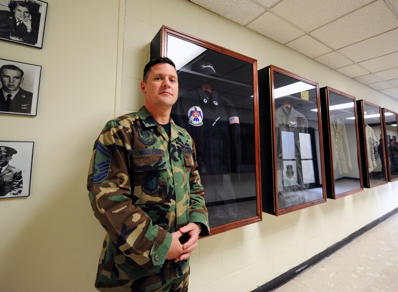 U.S. Air Force Senior Master Sgt. Rodney Woolever, 372nd Training Squadron F-16 Fighting Falcon engines instructor, stands next to a Thunderbird uniform he donated, 372nd TRS outside the gates of Shaw Air Force Base, S.C., Oct. 31, 2011. Woolever worked with the Thunderbirds as a maintenance superintendent from 2006 to 2009.  (U.S. Air Force photo by Airman 1st Class Tabatha Duarte/Released)