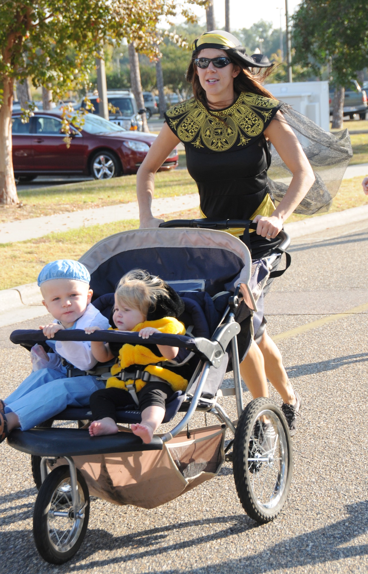 Misty Perry finishes the Halloween 5-kilometer run Oct. 28, 2011, at Keesler Air Force Base, Miss., with a time of 26 minutes, 50 seconds while pushing Kaeden, 2, and Kylynn, 10 months, also dressed in costume.  Perry, dressed as an Egyptian goddess, won first place in the costume contest. Perry is married to 1st Lt. Kyle Perry, 81st Inpatient Operations Squadron.  (U.S. Air Force photo by Kemberly Groue)