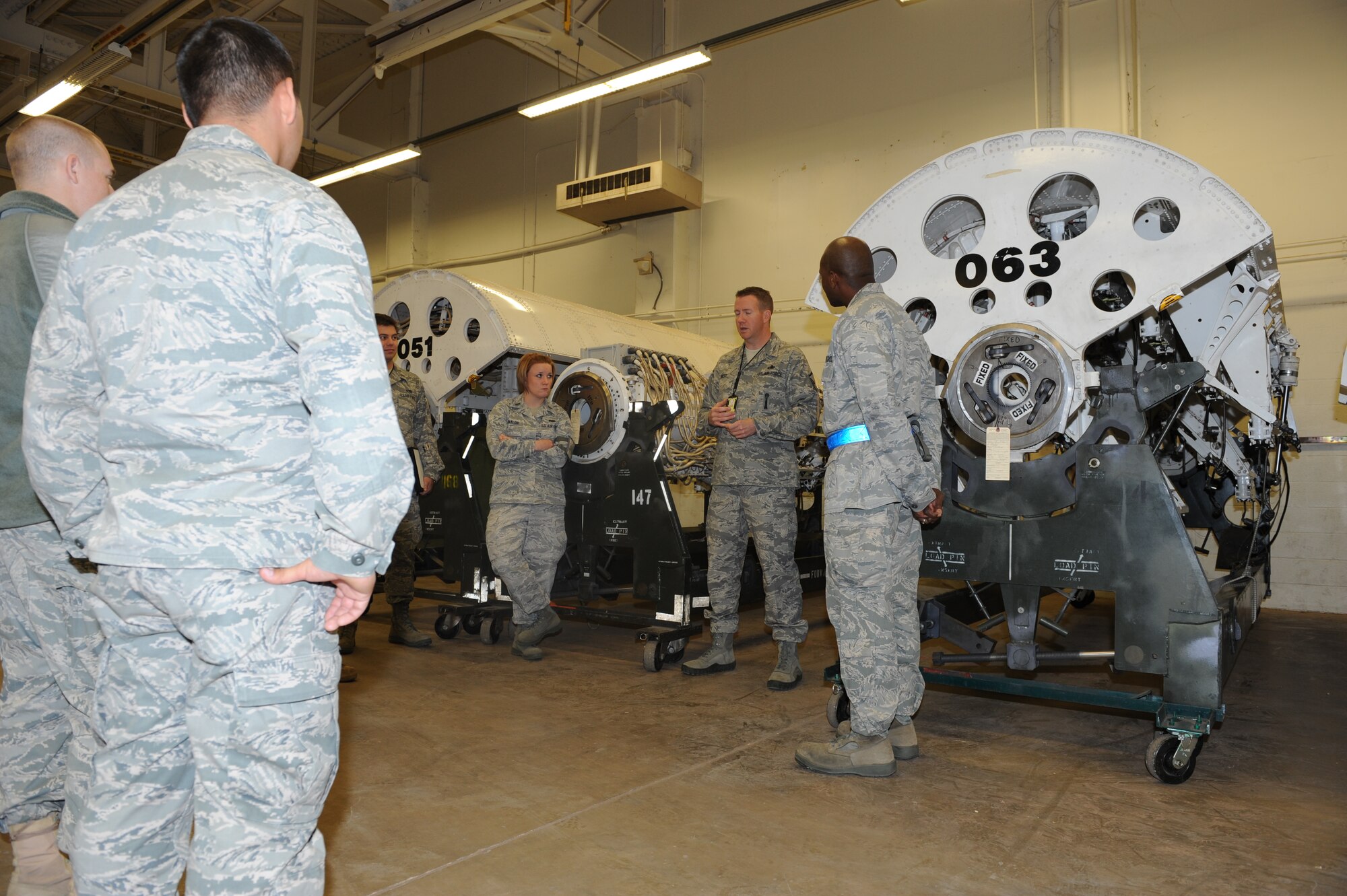 Master Sgt. Nathan Best, 7th Munitions Squadron, center, explains to a tour group how rotary launchers work Oct. 28, 2011, at Dyess Air Force Base, Texas. The tour consisted of an inside look of Dyess’ bomb shelters, the recycling of old bomb facilities and the repair of rotary launchers located inside of the B-1 Bomber.  (U.S. Air Force photo by Airman 1st Class Jonathan Stefanko/ Released)
