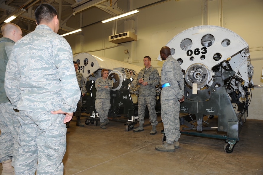 Master Sgt. Nathan Best, 7th Munitions Squadron, center, explains to a tour group how rotary launchers work Oct. 28, 2011, at Dyess Air Force Base, Texas. The tour consisted of an inside look of Dyess’ bomb shelters, the recycling of old bomb facilities and the repair of rotary launchers located inside of the B-1 Bomber.  (U.S. Air Force photo by Airman 1st Class Jonathan Stefanko/ Released)