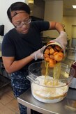 Petty Officer 3rd Class Ashley Shaw pours sweet potatoes into a mixture that will be used to make sweet potato bread at the Joint Base Charleston - Air Base Child Development Center. Shaw, a Machinist’s Mate, is working at the JB Charleston – Air Base CDC while waiting for orders to her next school assignment. (U.S. Navy photo/Petty Officer 1st Class Jennifer Hudson)