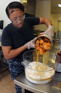Petty Officer 3rd Class Ashley Shaw pours sweet potatoes into a mixture that will be used to make sweet potato bread at the Joint Base Charleston - Air Base Child Development Center. Shaw, a Machinist’s Mate, is working at the JB Charleston – Air Base CDC while waiting for orders to her next school assignment. (U.S. Navy photo/Petty Officer 1st Class Jennifer Hudson)