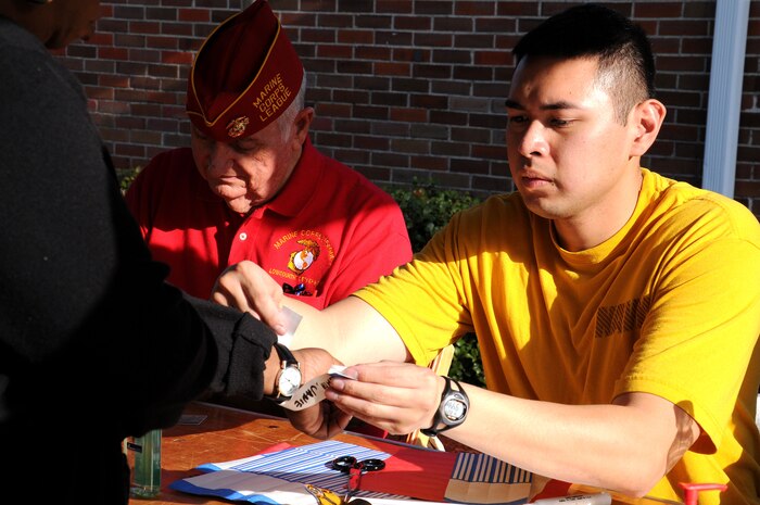 Petty Officer 2nd Class John Yuasensi places a wrist band on a participant during the check-in process of the Stand Down Against Homelessness at the Armory Park Community Center Oct. 27.  The Ralph H. Johnson Veteran Affairs Medical Center and Goodwill Industries of the Lowcountry sponsored the 12th annual Stand Down Against Homelessness. The event provided medical and dental assistance, clothing, food, haircuts and job and legal counseling for hundreds of homeless in the greater Charleston area.  Yuasensi is a Ship’s Serviceman from the Unaccompanied Personnel Housing at Joint Base Charleston-Weapons Station. (U.S. Navy photo/Petty Officer 3rd Class Brannon Deugan)
