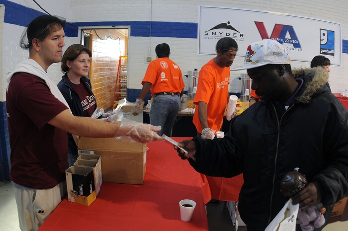 Navy Lt. j.g. David Guajardo and Lt. j.g. Jessica Warner hand out condiments for hot cups of coffee to help cope with Thursday’s cold morning during the Stand Down Against Homelessness at the Armory Park Community Center, Oct. 27.  The Ralph H. Johnson Veteran Affairs Medical Center and the Goodwill Industries of the Lowcountry sponsored the 12th annual Stand Down Against Homelessness.  The event provided medical and dental assistance, clothing, food, haircuts and job and legal counseling for hundreds of homeless in the greater Charleston area.   Guajardo and Warner are both assigned to the Naval Health Clinic Charleston. (U.S. Navy photo/Petty Officer 3rd Class Brannon Deugan)