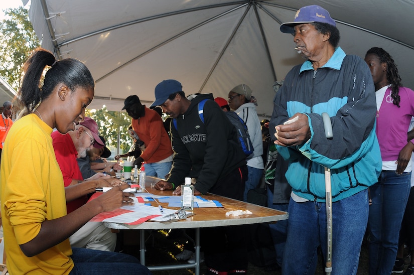 Petty Officer 3rd Class Pakisha Johnson, fills out paperwork for participants of the Stand Down against Homelessness at the Armory Park Community Center Oct. 27. The Ralph H. Johnson Veteran Affairs Medical Center and Goodwill Industries of the Lowcountry sponsored the 12th annual Stand Down Against Homelessness. The event provided medical and dental assistance, clothing, food, haircuts and job and legal counseling for hundreds of homeless people in the greater Charleston area.  Johnson is a Machinist’s Mate assigned to Unaccompanied Personnel Housing at Joint Base Charleston - Weapons Station. (U.S. Navy photo/Petty Officer 1st Class Jennifer Hudson)