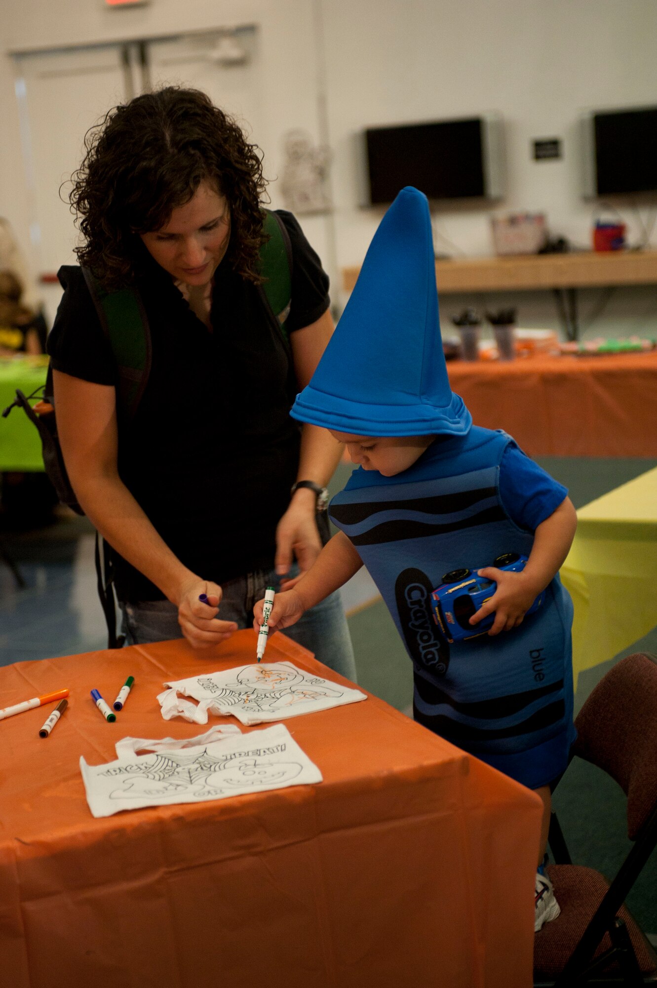 A mother helps her child color during the Children's Halloween Party, Oct. 31, 2011, at the Community Center, Incirlik Air Base, Turkey. The party included games, treats and Halloween crafts. (U.S. Air Force photo by Senior Airman Clayton Lenhardt/Released)