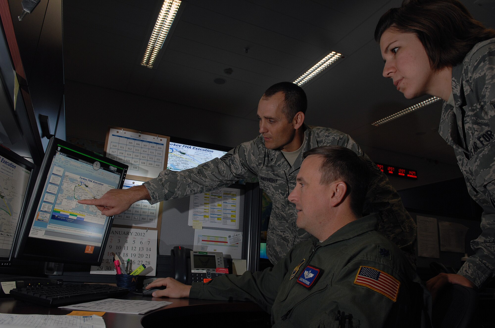 Master Sgt. Richard Anthony, 603rd Air and Space Operations Center (AOC) mission planner, points out planning information to Lt. Col. John Passmore, Airlift Control Team chief, as Airman 1st Class Jackie Bonkoski, mission controller, looks on.  603rd AOC personnel planned and controlled aircraft missions that delivered humanitarian assistance supplies to people affected by the Oct. 23 earthquake in Turkey.  (U.S. Air Force photo by Chief Master Sgt. David W. Richards) (Released)