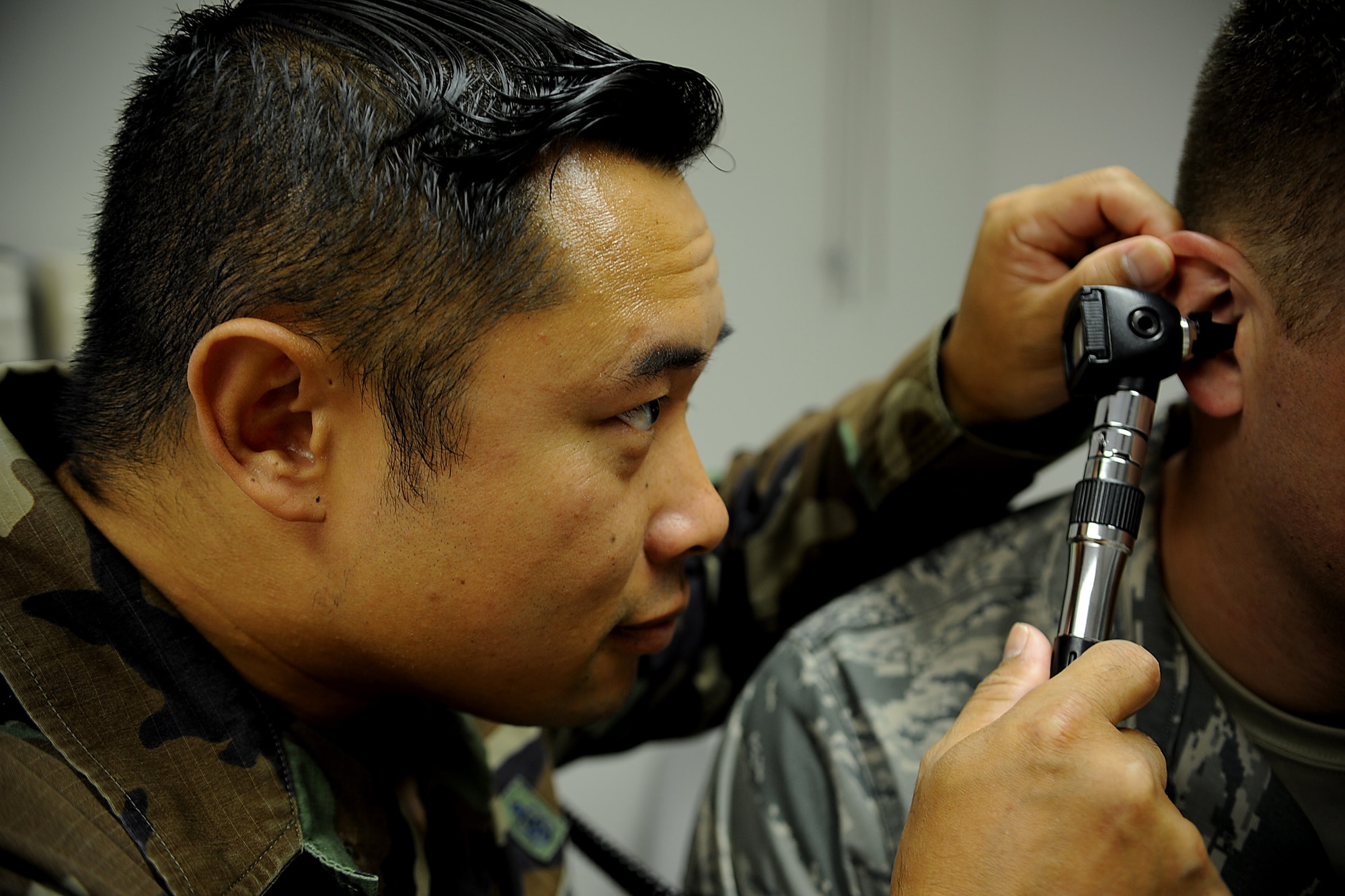 U.S. Air Force Tech. Sgt. Jahnpayne Bowling, 67th Fighter Squadron independent duty medical technician, works with a patient while wearing the Battle Dress Uniform on Kadena Air Base, Japan, Oct. 31. The BDU was in service for nearly three decades and had a final wear date of Oct. 31, 2011. (U.S. Air Force photo/Staff Sgt. Christopher Hummel/released)