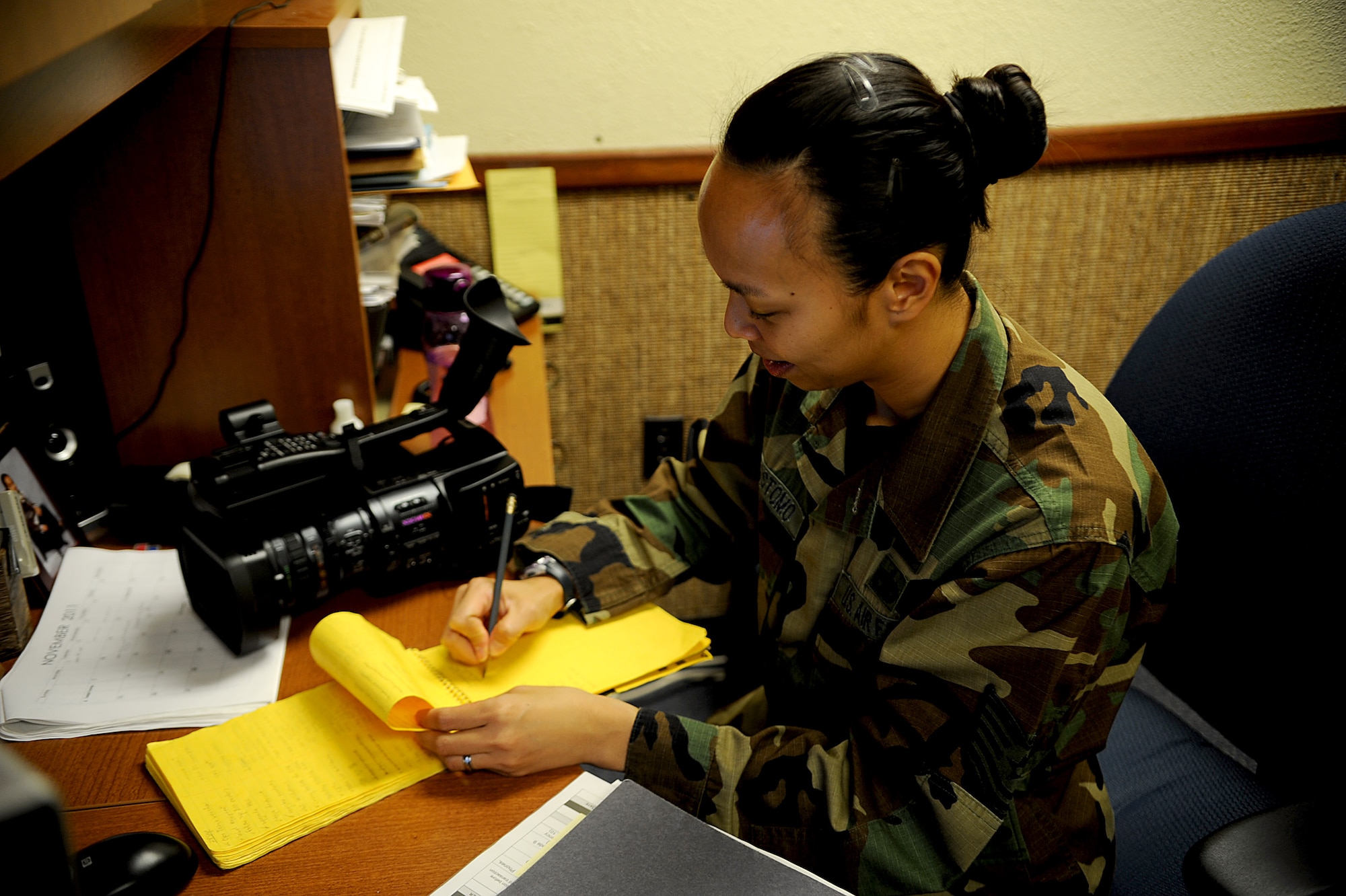 U.S. Air Force Tech. Sgt. Renee Crisostomo, 18th Wing Public Affairs NCO in charge of broadcasting, wears the Battle Dress Uniform while writing a shooting script on Kadena Air Base, Japan, Oct. 31. The BDU was in service for nearly three decades and was worn by all services until 2005. (U.S. Air Force photo/Staff Sgt. Christopher Hummel/released)