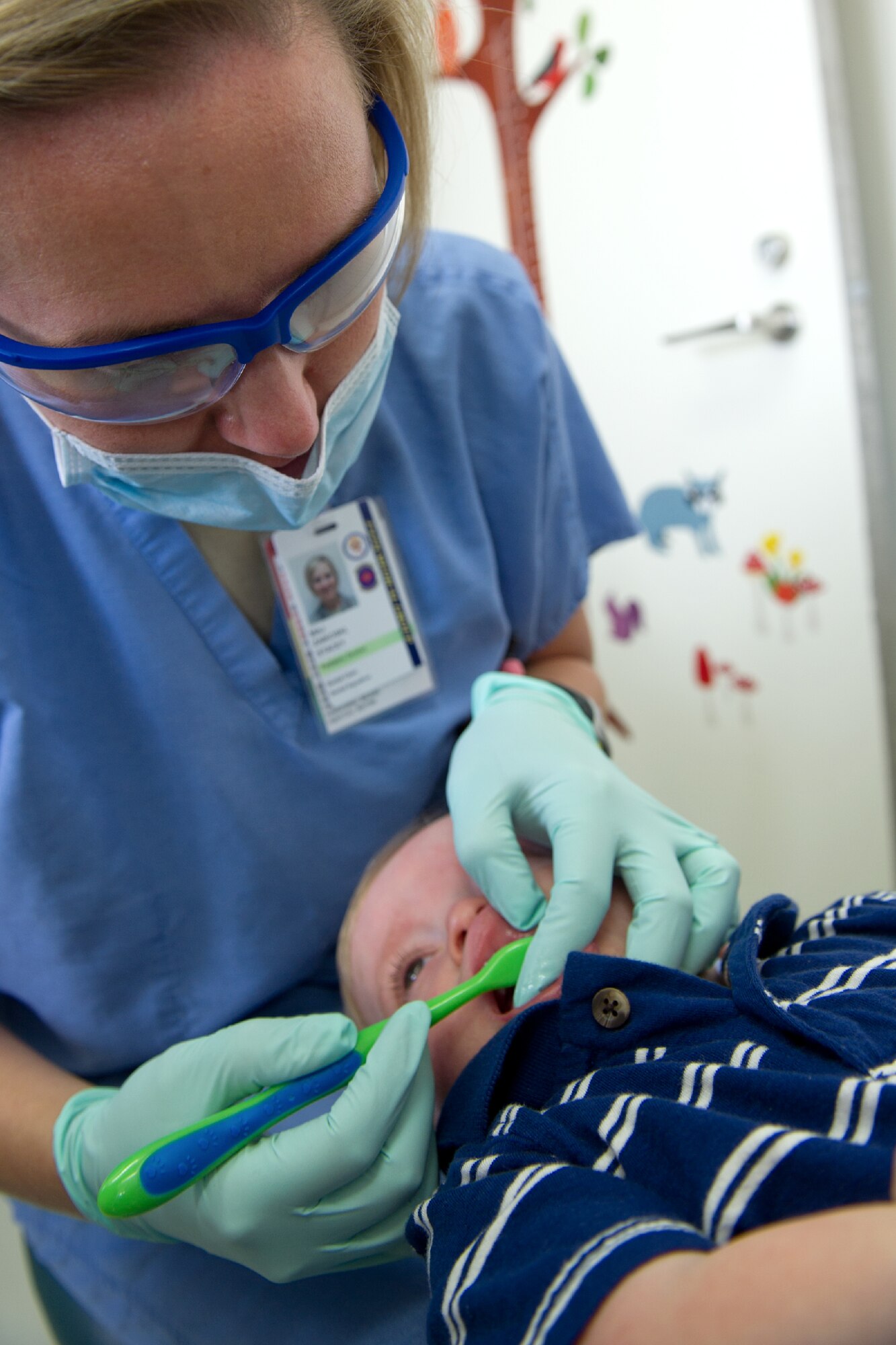 YOKOTA AIR BASE, Japan -- Maj. Stacey Zaikoski, 374th Dental Squadron pediatric dentist, checks a baby's teeth during his first dental appointment at Yokota's dental clinic, Oct. 28, 2011. Zaikoski said that the earlier the dental visit, the better the chance of preventing dental problems. (U.S. Air Force photo/Osakabe Yasuo)