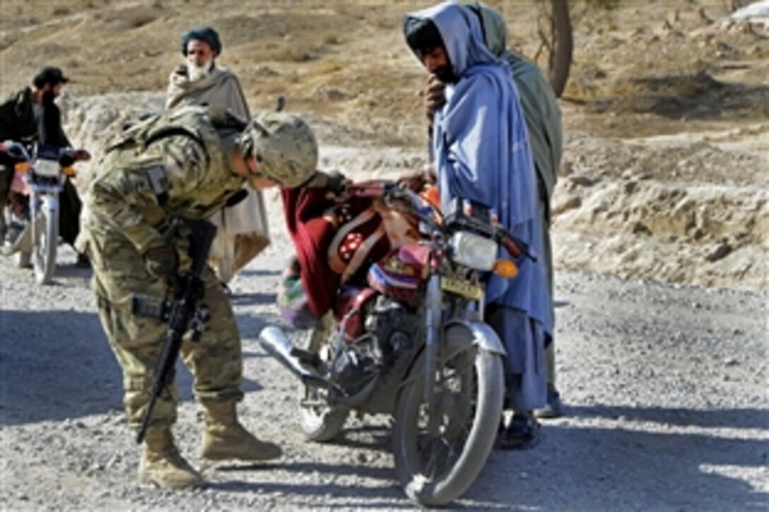 U.S. Army Sgt. Gary Melton conducts vehicle and personnel searches at a traffic control point near Kakrak in Afghanistan's Uruzgan province, Oct. 28, 2011. Melton is assigned to Provincial Reconstruction Team Uruzgan's security forces. Team members escorted a local contractor to a nearby culvert to assess damages for repair.