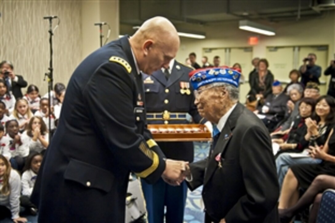 Army Chief of Staff Gen. Raymond T. Odierno presents a Bronze Star Medal and the Army Chief of Staff coin to George Joe Sakato at the World War II Nisei Veterans Program National Veterans Network tribute to the 100th Infantry Battalion, 442nd Regimental Combat Team and Military Intelligence Service in Washington, D.C., Nov. 1, 2011. Sakato is a Medal of Honor recipient and a Japanese-American World War II veteran.