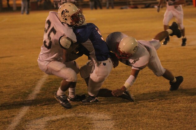 MWSS-374 Rhinos’ runninng back Alex Esprza attempts to break through the MCCES Mustangs’ defensive line during the Commanding General’s Intramural Football League playoff game at Felix Field Nov. 2, 2011.::r::::n::