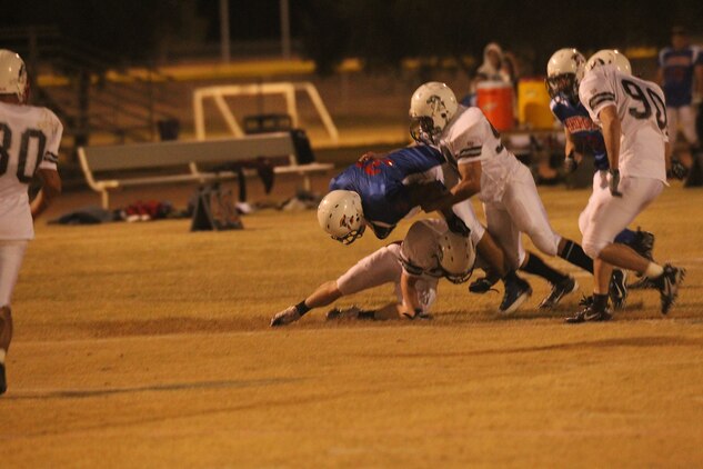 MWSS-374 Rhinos’ running back Byron Robinson is taken down by the MCCES Mustangs’ defensive line during the Commanding General’s Intramural Football League playoff game at Felix Field Nov. 2, 2011.::r::::n::