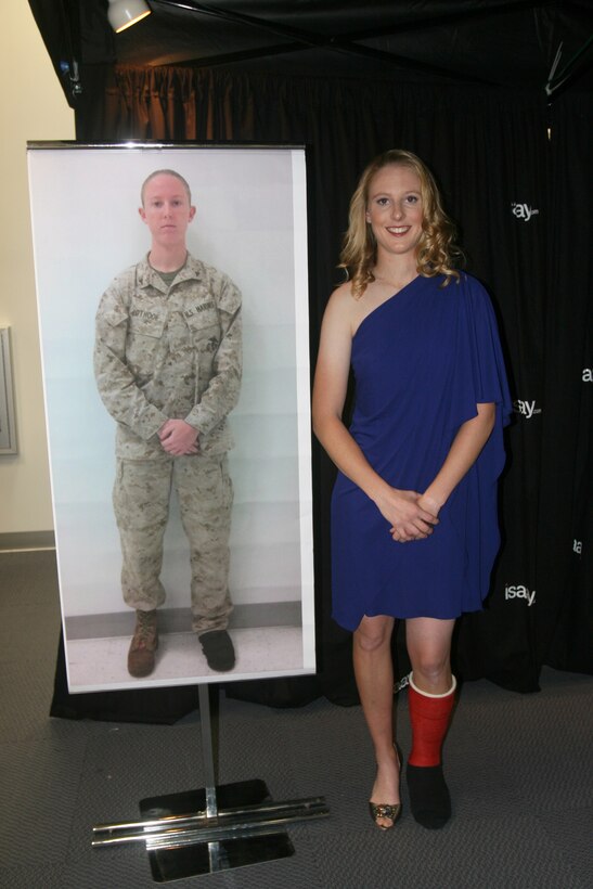 A transformed Lance Cpl. Danielle N. Pothoof, from Bay City, Mich., a motor transportation operator with 2nd Marine Logistics Group stands next to her “before” picture after receiving a makeover Nov. 2, 2011, aboard Camp Lejeune, N.C.  Marine Corps Community Services and 2nd Marine Expeditionary Force command chose wounded warriors for makeovers as part of the Marine Corps Exchange grand opening celebration.    (Photo by Cpl. Bruno J. Bego)