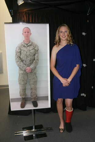 A transformed Lance Cpl. Danielle N. Pothoof, from Bay City, Mich., a motor transportation operator with 2nd Marine Logistics Group stands next to her “before” picture after receiving a makeover Nov. 2, 2011, aboard Camp Lejeune, N.C.  Marine Corps Community Services and 2nd Marine Expeditionary Force command chose wounded warriors for makeovers as part of the Marine Corps Exchange grand opening celebration.    (Photo by Cpl. Bruno J. Bego)