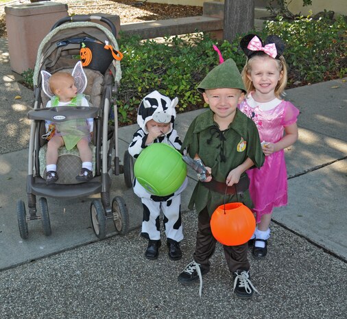 A group of kids show off their costumes while trick or treating through base offices, during a Halloween parade at Beale AFB, Oct. 31, 2011. The Community Activity Center held the parade as an opportunity for kids to dress up and go trick- or- treating. (U.S. Air Force photo by Senior Airman Samantha Krolikowski/ Released)