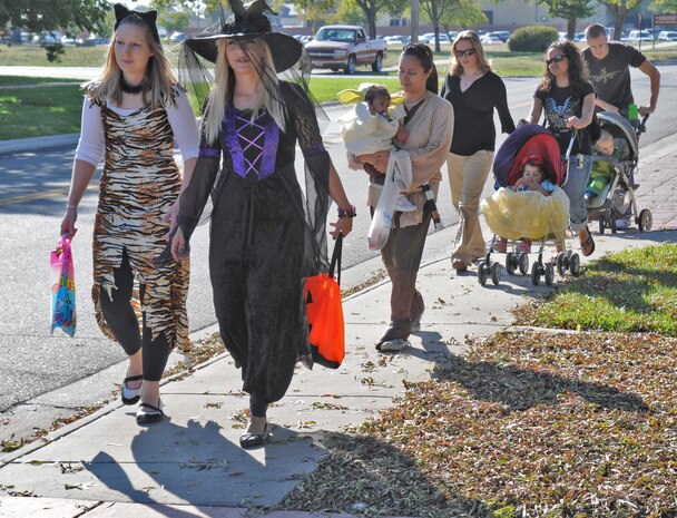 Parents take their kids on a Halloween parade at Beale AFB, organized by the Community Activity Center, Oct. 31, 2011. The Halloween parade was a free trick- or- treat activity for kids in several offices around main base. (U.S. Air Force photo by Senior Airman Samantha Krolikowski/ Released)