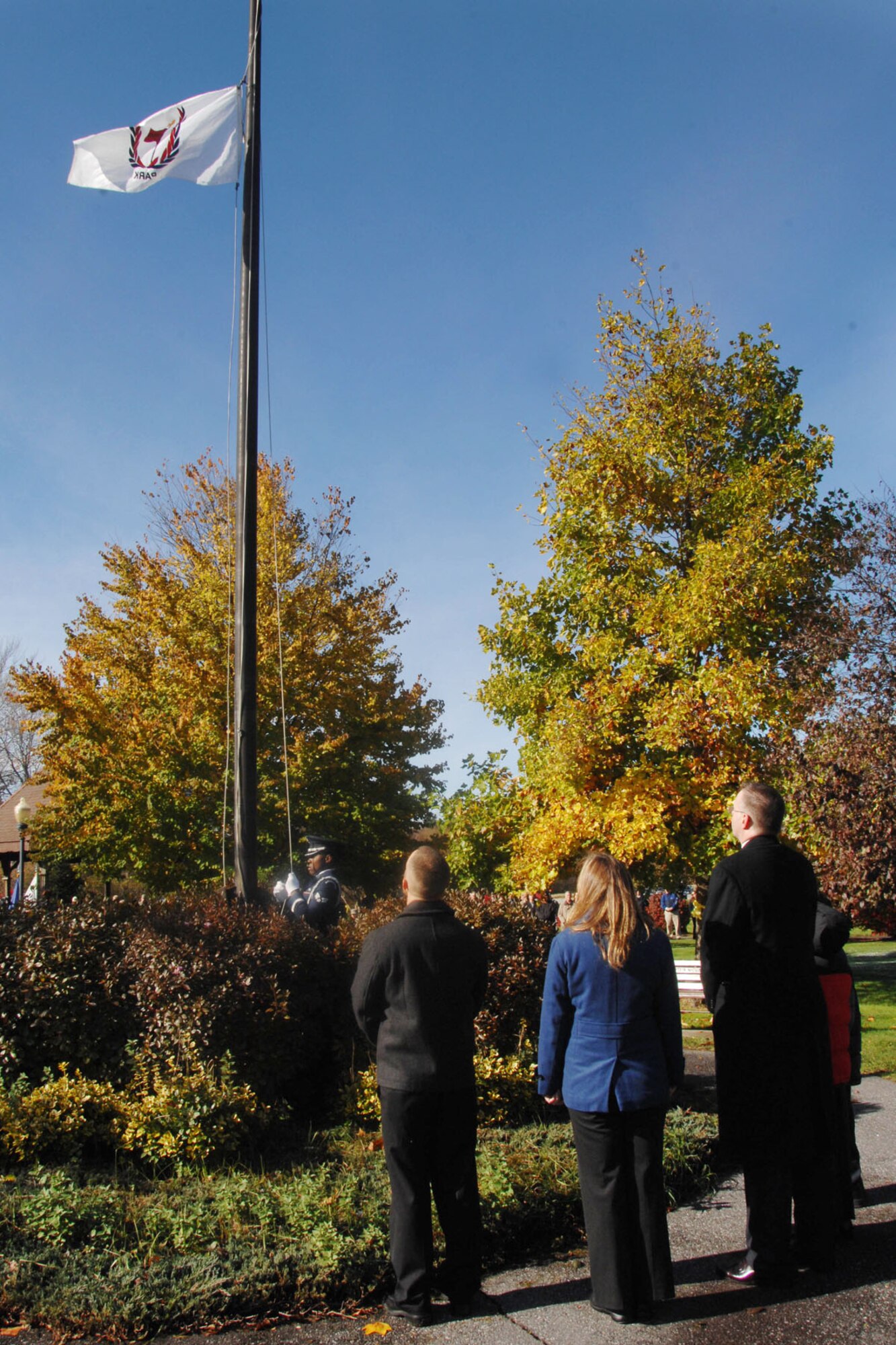 HANSCOM AIR FORCE BASE, Mass. – Family members watch as the Memorial Park flag is raised in honor of three former Hanscom employees whose lives and accomplishments were an integral part of the base. Thomas P. O'Mahony, Joseph E. Mardo and retired Lt. Col. Dennis P. McCorry were also honored with a tree and bronze plaque dedicated in their memory during the ceremony. (U.S. Air Force photo by Linda LaBonte Britt)
