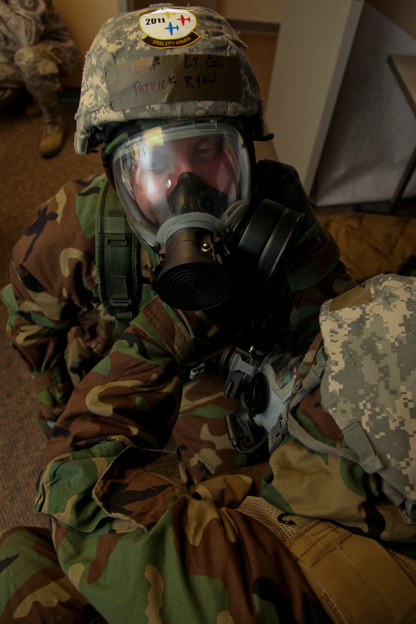 PITTSBURGH IAP ARS, PA -- Master Sgt. Christoper Mason, 911th Civil Engineer emergency management craftsman, assists Lt. Col Ryan, 911th Mission Support Group commander, tighten his protective helmet during an Attack Response Exercise (ARE), Oct. 2. The ARE was used to test the 911 AW's command and control function's ability to ensure proper and accurate information flow. (U.S. Air Force photo/Senior Airman Joshua J. Seybert)
