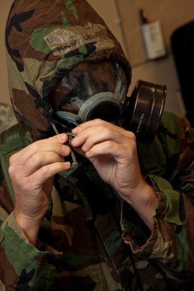 PITTSBURGH IAP ARS, PA -- Lt. Col. Brady Johnson, 911th Civil Engineer Squadron commander, puts his Mission Oriented Protective Posture coat hood over his protective mask during an Attack Response Exercise, Oct. 2. Colonel Johnson passed information from the Emergency Operation Center to members of the CES Unit Control Center during the exercise. (U.S. Air Force photo/Senior Airman Joshua J. Seybert)
