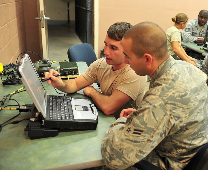 U.S. Air Force Senior Airman Marc Goralski, left, 823rd Base Defense Squadron fire team member, explains to Airman 1st Class Ryan Cantatore, 105th Security Forces Squadron fire team member, how a to operate a blue force tracker during a joint training exercise at Camp Smith, N.Y., Oct. 27, 2011. Airmen broke into small groups for hands-on training after taking a basic communications course. This is Goralski’s third time training with the 105th SFS and he has been deployed with them before. (U.S. Air Force photo by Staff Sgt. Stephanie Mancha/Released)
