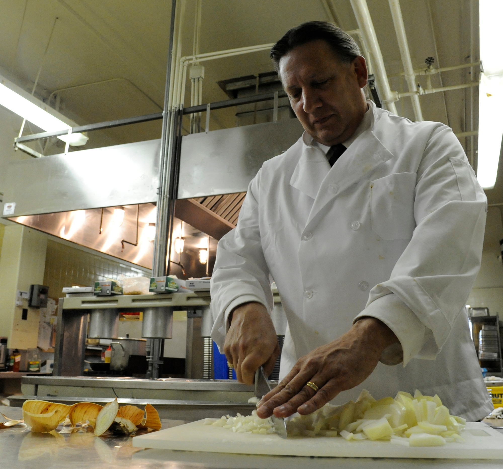 LAUGHLIN AIR FORCE BASE, Texas -- Bruce Hiott, General Manager of Laughlin’s Clubs, chops onions in prepping for a meal at Club XL Nov. 1. Hiott is responsible for many of the social activities on base, including Wing Wednesday and holiday parties. U.S. Air Force photo/Airman 1st Class Nathon L. Maysonet)