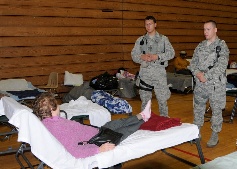 Members of the  104th Fighter Wing Security Forces squadron speak with an elderly lady  utilizing the warming-shelter at Springfield Central High School on November 2, 2011. They are providing augmented security following the unusually snow storm that hit the eastern seaboard Oct 29-30th 2011.  (Photograph by TSgt. Melanie J Casineau)