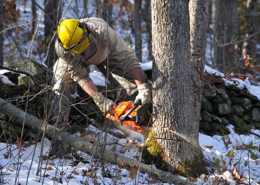 Senior Master Sgt.  Robert Dickinson, a member of the 104th Fighter Wings Logistic Readiness Squadron, in Westfield Mass., cuts down a tree that is blocking a road in Hampden Mass., on Tue, November 1, 2011.  He and more than 50 saw-teams were activated to support clean-up efforts in the state following the unusually snow storm that hit the eastern seaboard Oct 29-30th 2011. (photograph by Maj. Matthew T. Mutti, 104FW/CCE)