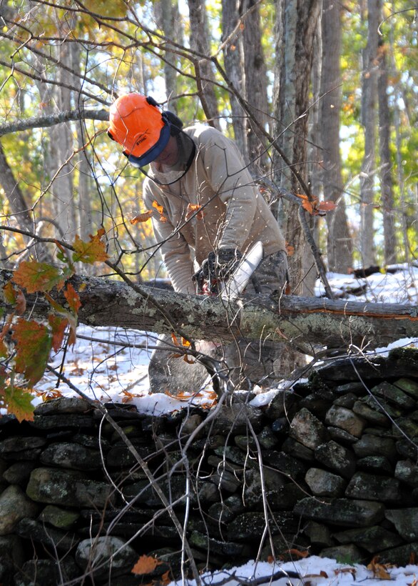 Master Sgt.  James Dunn, an aircraft maintenance technician at the 104th Fighter Wing, Westfield Mass., cuts down a tree that is blocking a road in Hampden Mass., on Tue, November 1, 2011.  He and more than 50 saw-teams were activated to support clean-up efforts in the state following the unusually snow storm that hit the eastern seaboard Oct 29-30th 2011. (photograph by Maj. Matthew T. Mutti, 104FW/CCE)