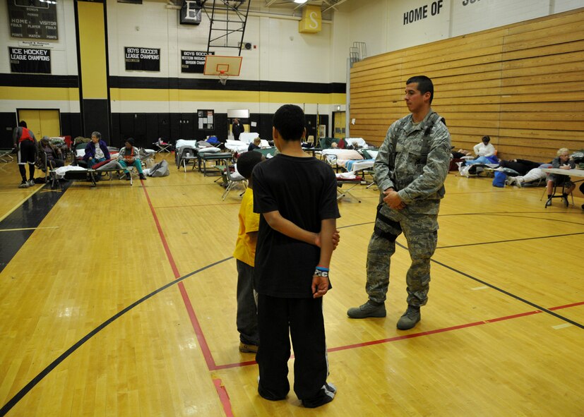 Senior Airman Steven Vignault, 104th Fighter Wing Security Forces Member,  speaks with children utilizing the warming-shelter at Springfield Central High School on November 1, 2011 as he provides augmented security following the unusually snow storm that hit the eastern seaboard Oct 29-30th 2011.  (photograph by Maj. Matthew T. Mutti, 104FW/CCE)