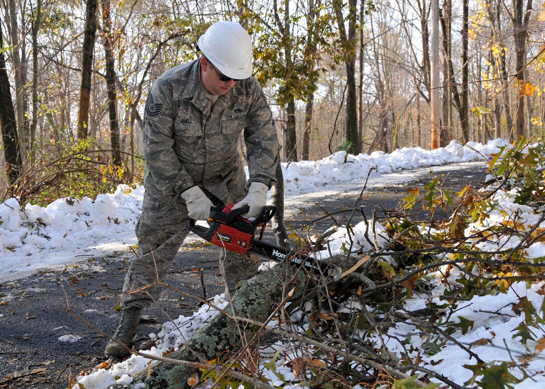Technical Sgt. Shawn Amell cuts a tree limb blocking traffic in Hampden Mass. on the second day of clean-up operations in Western Mass.  More than 50 chain saw teams are deployed by the Mass. National Guard to assist in the clean-up following the devastating snow storm Oct 29-30th. (photograph by Maj. Matthew Mutti, 104FW/PA)