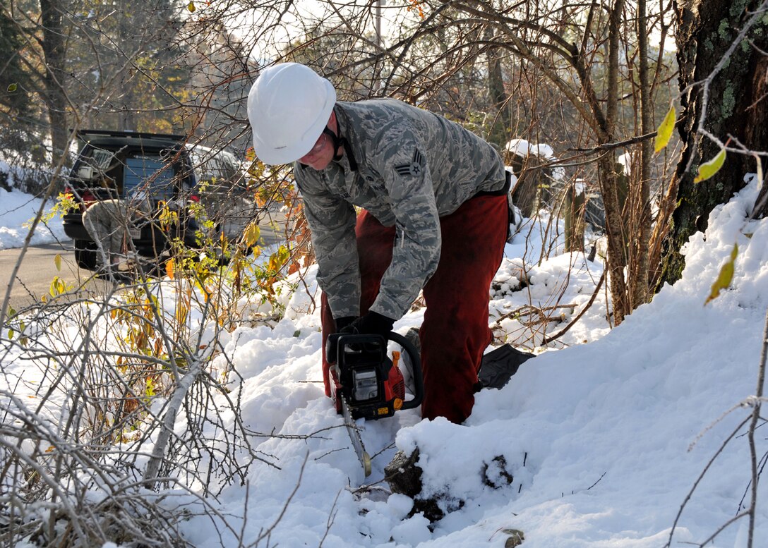 Master Sgt. Diaz and Airman 1st Class Rosario clear the road in front of an disabled South Hadley resident on the second day of clean-up operations in Western Mass.  More than 50 chain saw teams are deployed by the Mass. National Guard to assist in the clean-up following the devastating snow storm Oct 29-30th. (photograph by Maj. Matthew Mutti, 104FW/PA)