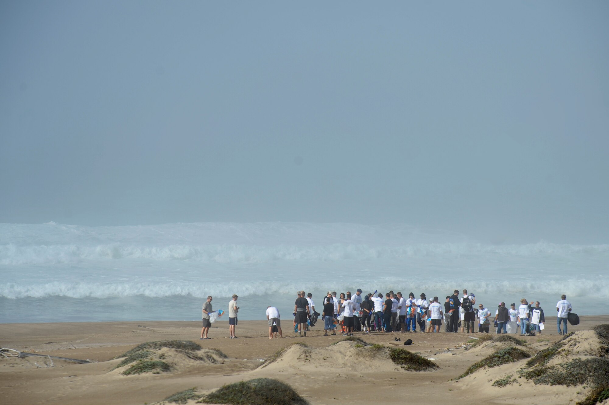 VANDENBERG AIR FORCE BASE, Calif. -- Volunteers round up to receive trash bags and gloves during the Beach Cleanup Day at Surf Beach on base Tuesday, Nov. 1, 2011. More than 120 volunteers from base participated in the event, which covered nine miles of beach. (U.S. Air Force photo/Staff Sgt. Andrew Satran) 

 
 